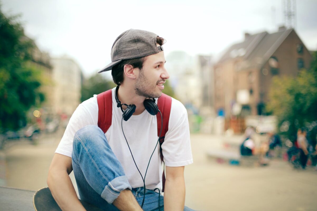 man in white shirt wearing black cap and black headphones