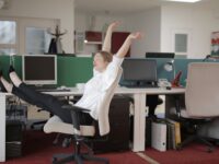 female office worker relaxing with feet on table
