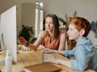 photo of woman tutoring young boy