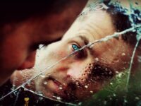 blue eyed man staring at the mirror