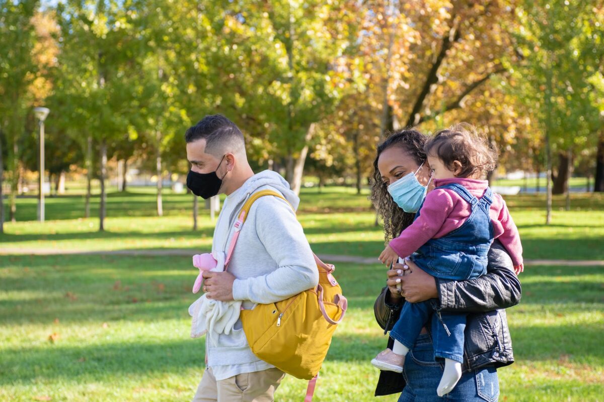 a woman carrying her daughter near a man