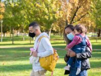 a woman carrying her daughter near a man