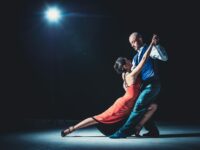 Mujer y hombre bailando bajo la luz