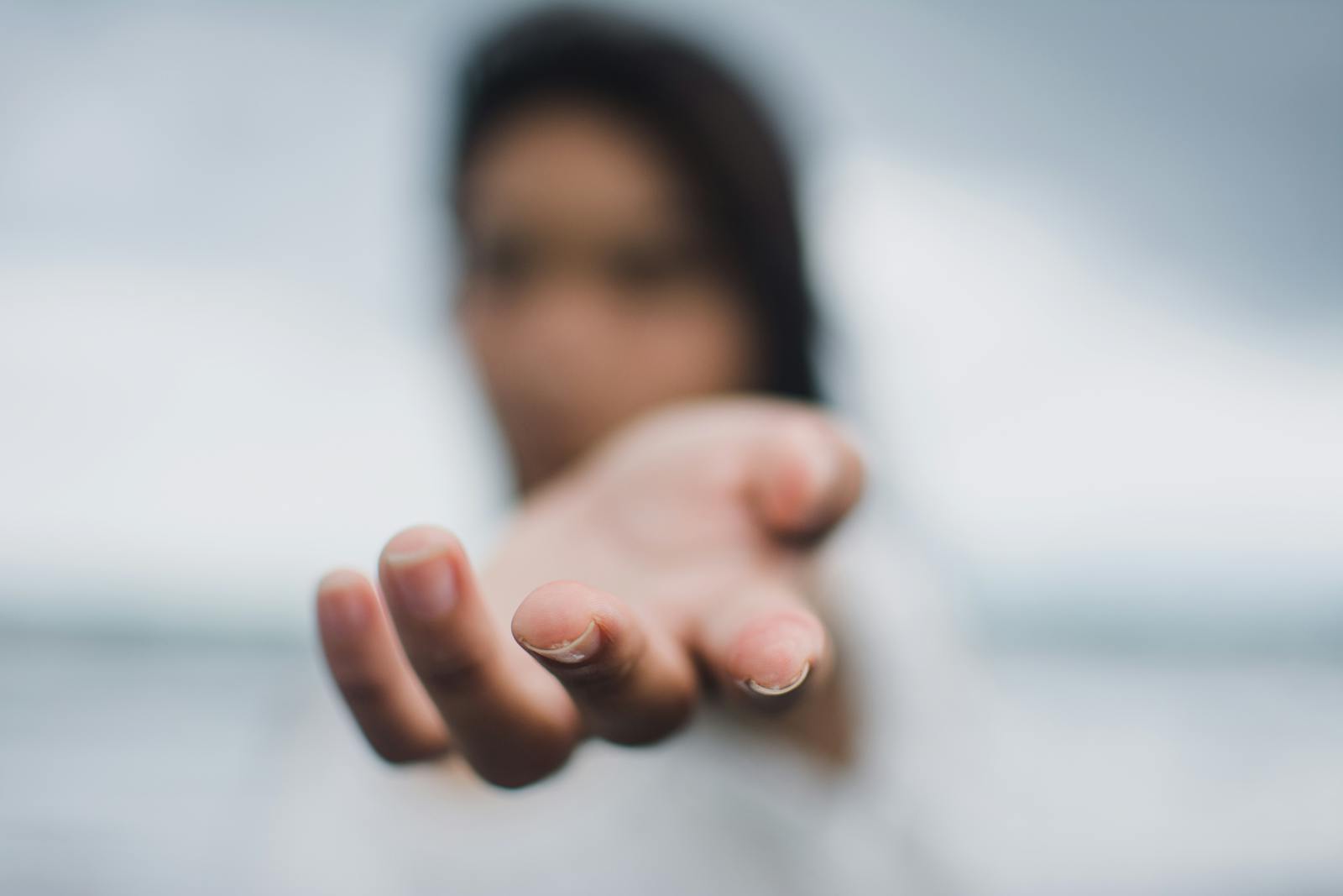 Una imagen de enfoque suave que resalta una mano extendida, que simboliza conexión o ayuda.