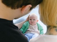 Padres mirando amorosamente a su bebé en un ambiente hogareño y acogedor.