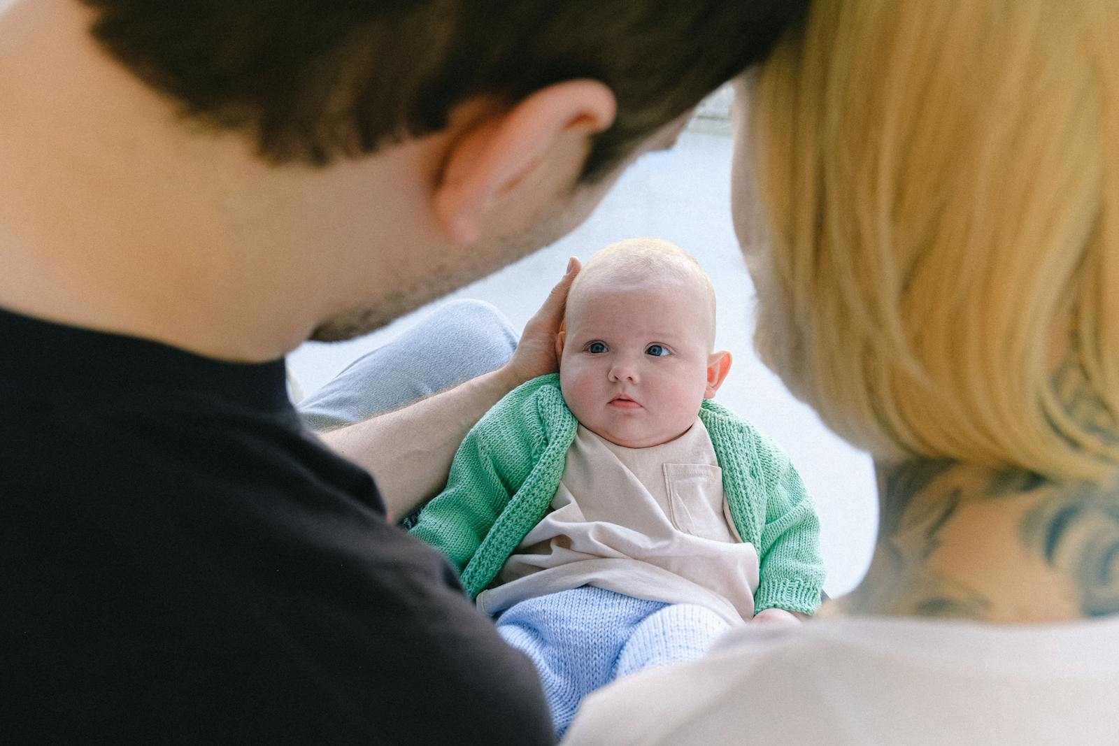Padres mirando amorosamente a su bebé en un ambiente hogareño y acogedor.