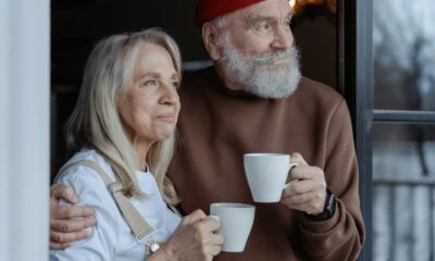 Hombre y mujer sosteniendo tazas de cerámica blanca
